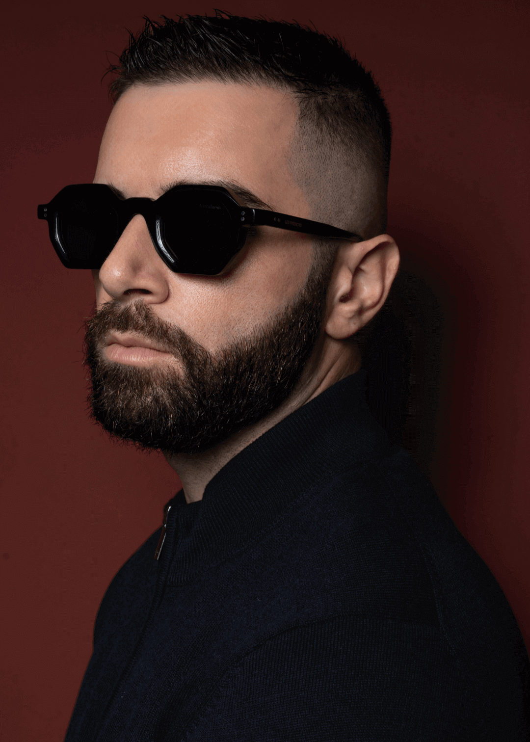 Male model is wearing black rectangular sunglasses, slightly left side profile