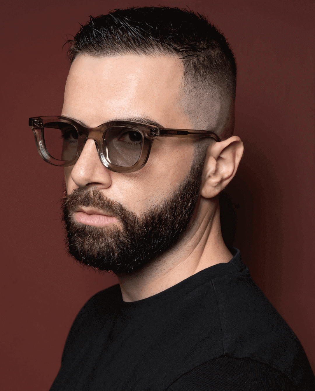 Male model wearing green sunglasses with transparent lens, slight left side profile 