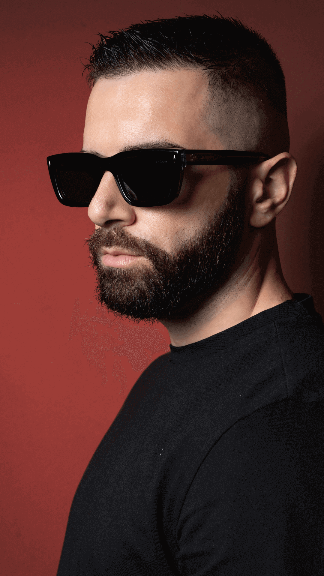 Male model wearing metal black rectangle sunglasses, left side profile