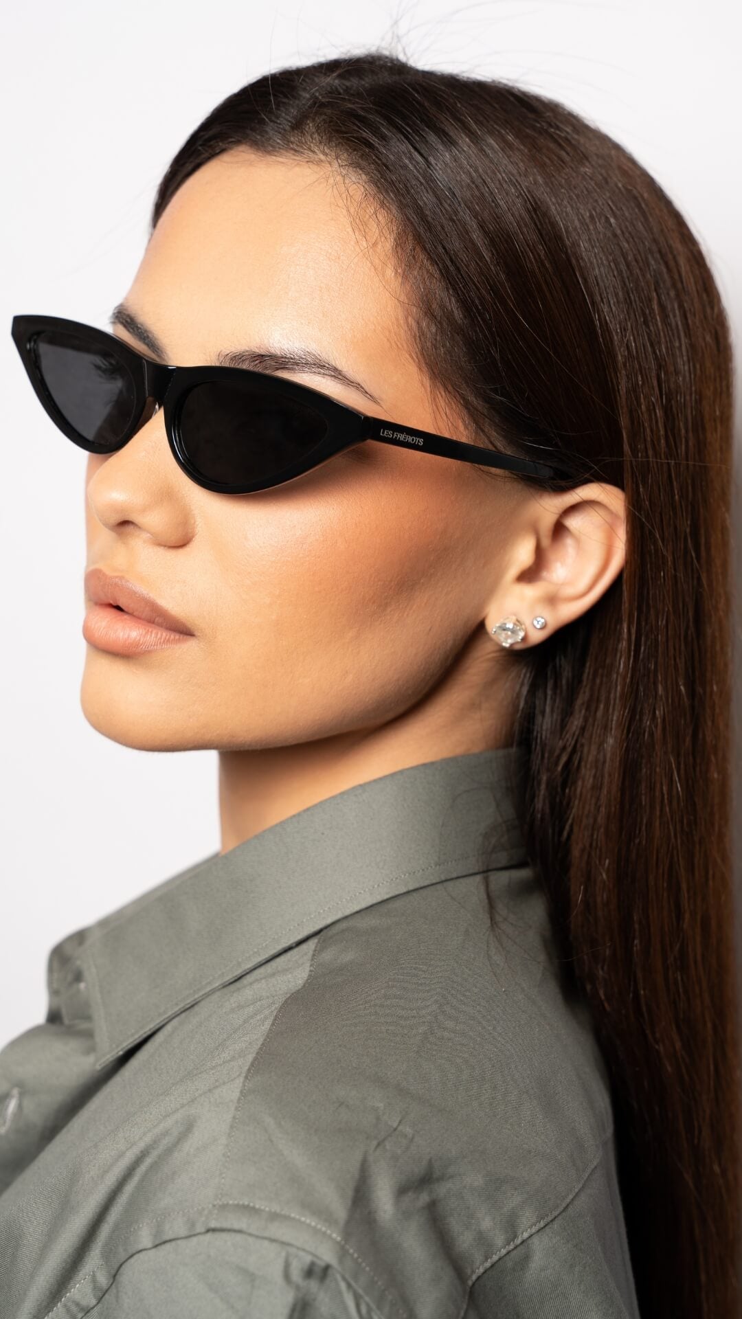 female model wearing black cat eye sunglasses, left side profile
